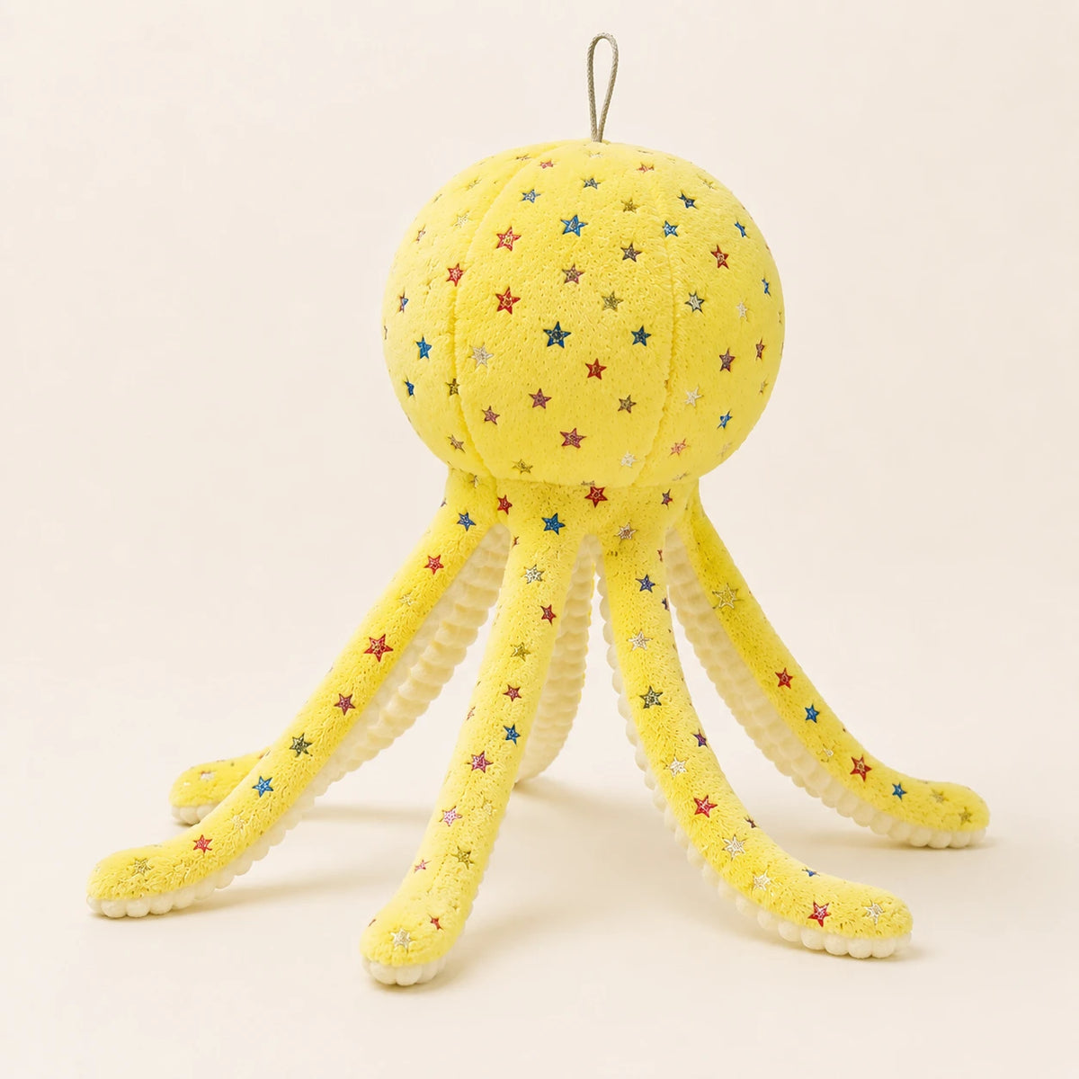 Peluche pieuvre jaune à étoiles, autre angle montrant les longues pattes