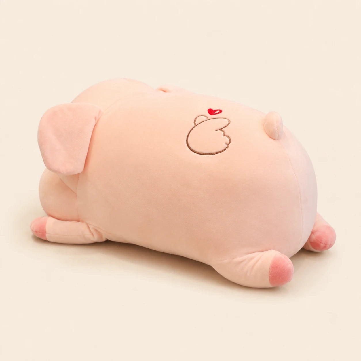 Peluche cochon dodu rose, vue de trois-quarts arriere sur fond ivoire