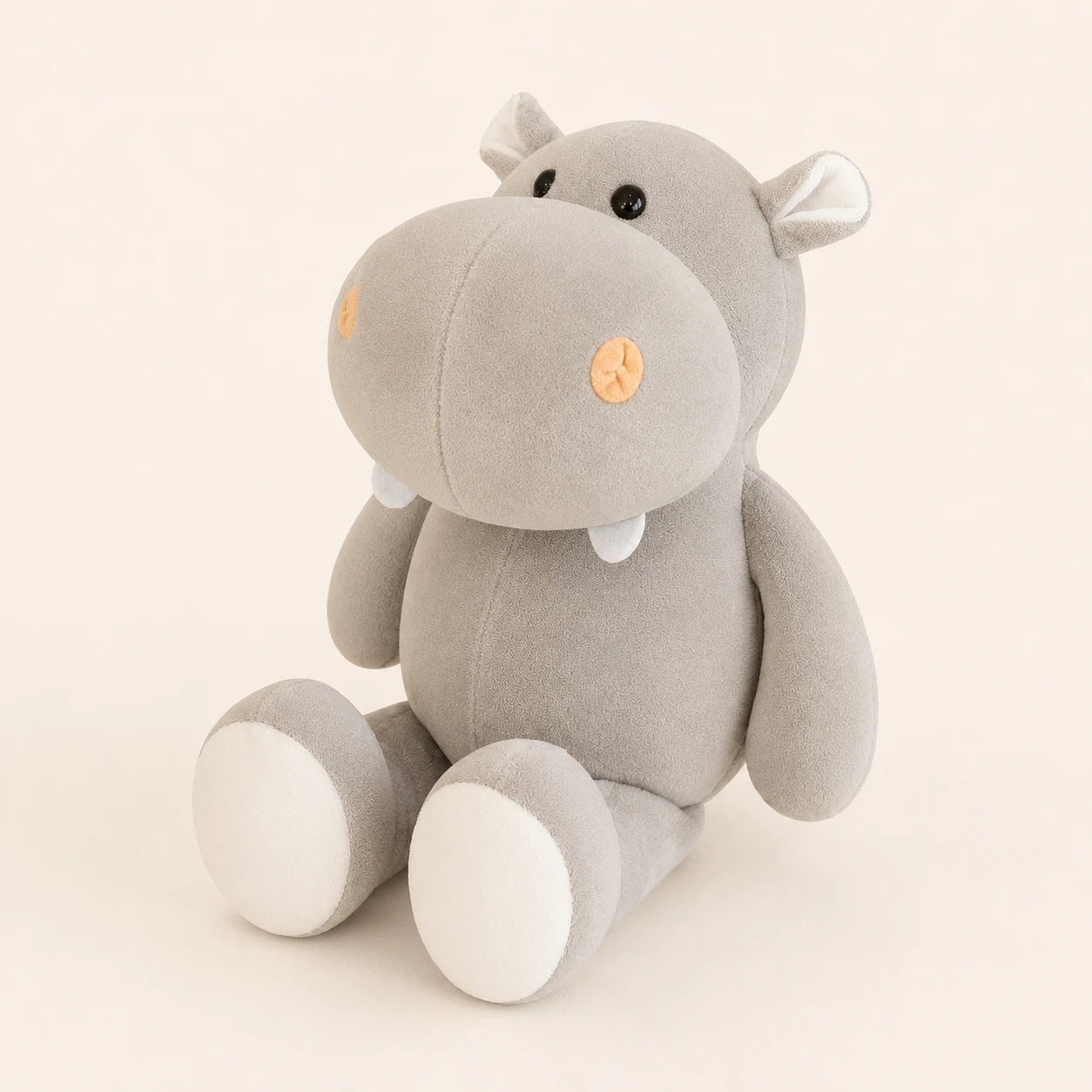 Peluche hippopotame grise vue de trois-quarts sur fond ivoire