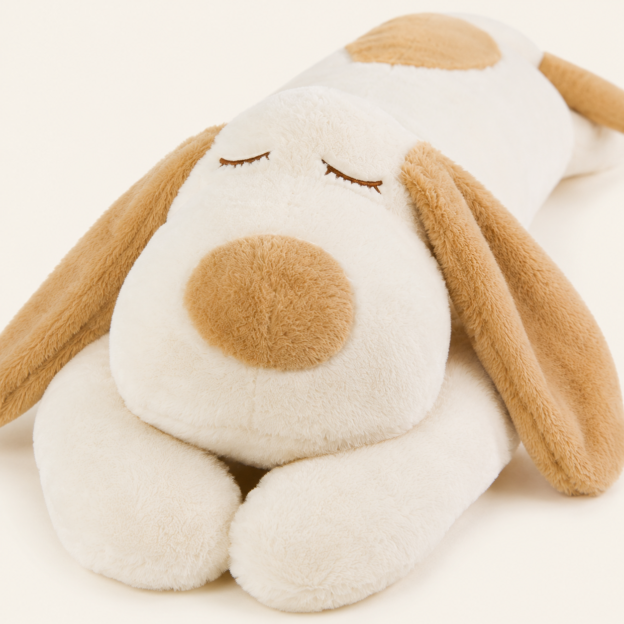 Peluche chien allongé, détail du visage et des oreilles