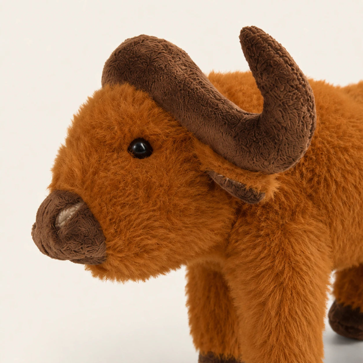 Gros plan sur le visage et les cornes de la peluche vache Highland
