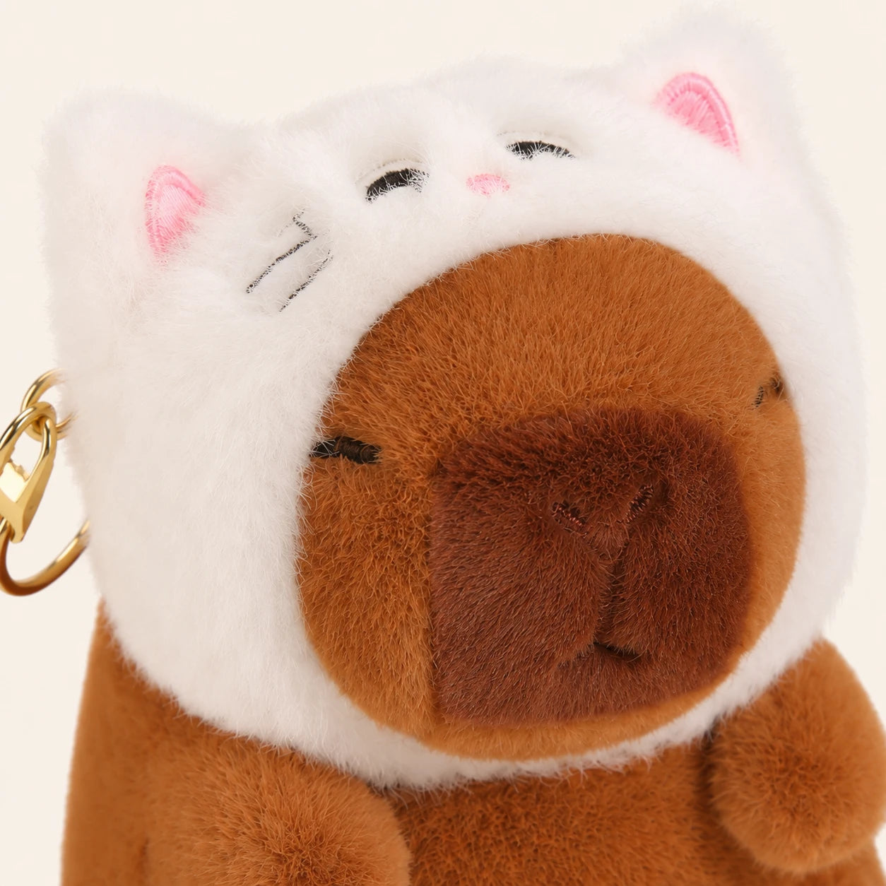 Gros plan du visage de la peluche capybara à capuche chat - Royaume Peluche