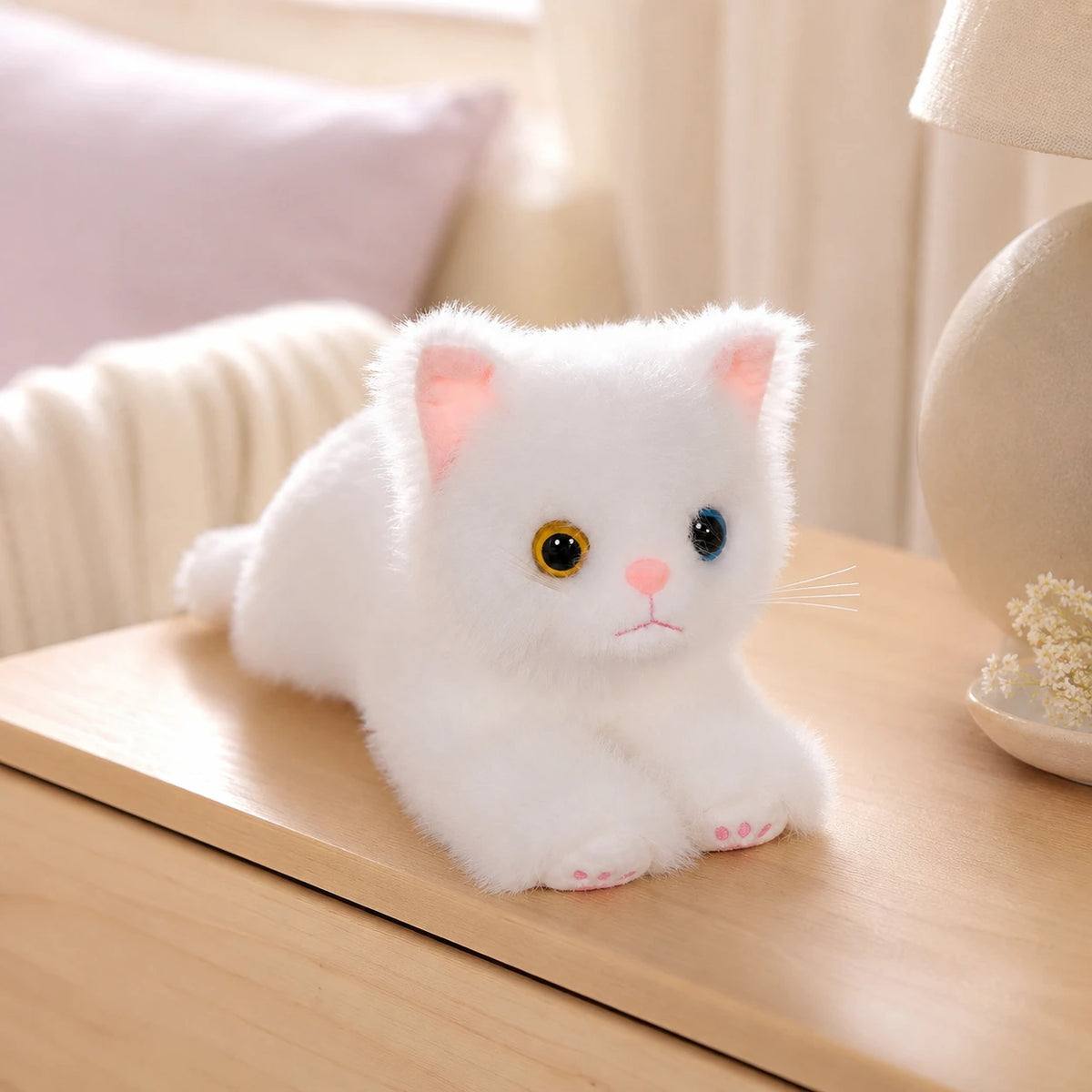 Peluche chat blanc posée sur une table dans un intérieur cosy