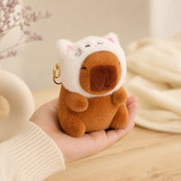 Peluche capybara chat tenue en main, mise en situation - Royaume Peluche