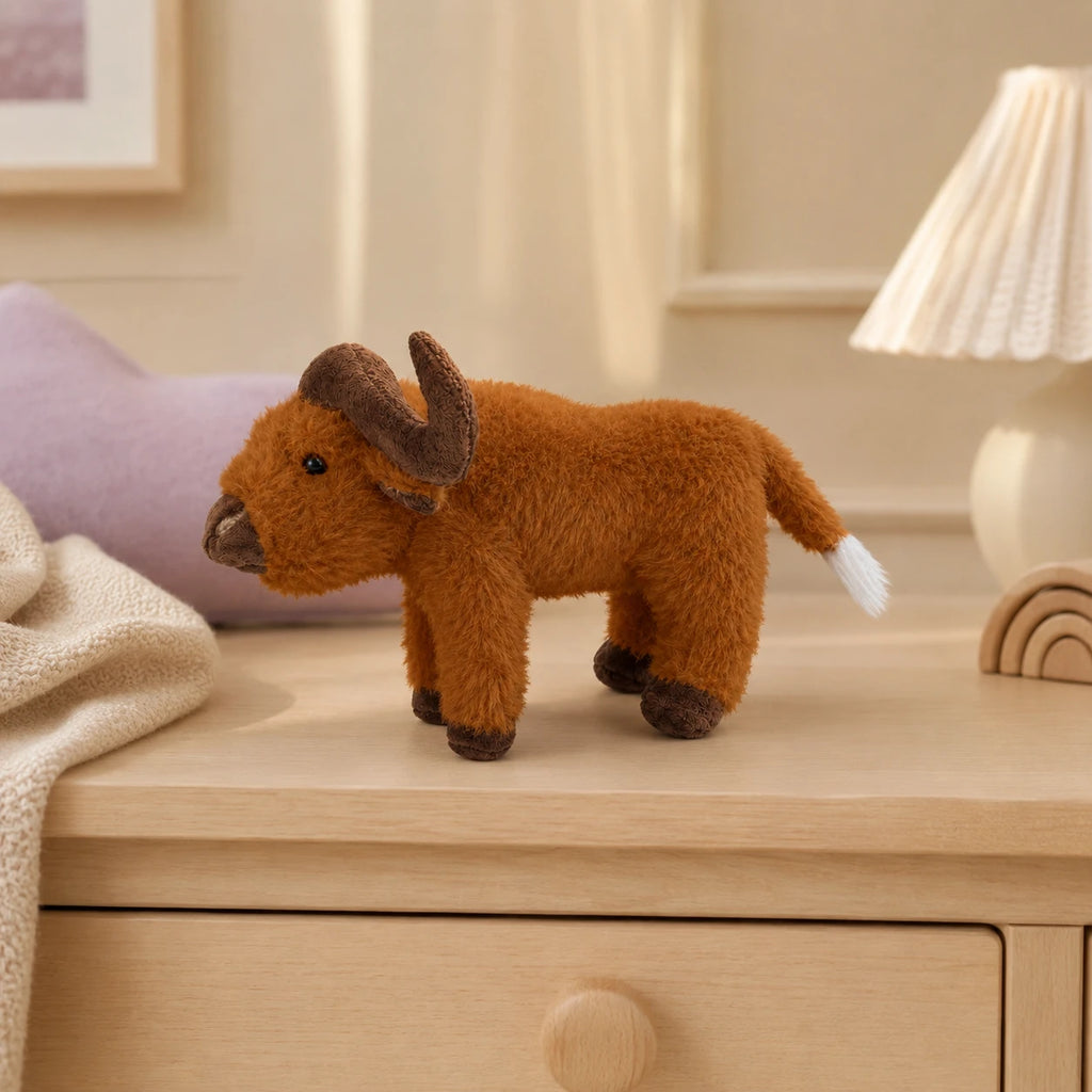 Peluche vache Highland posée sur une commode dans une chambre douce