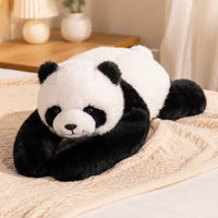 Peluche panda posée en situation sur un lit cosy
