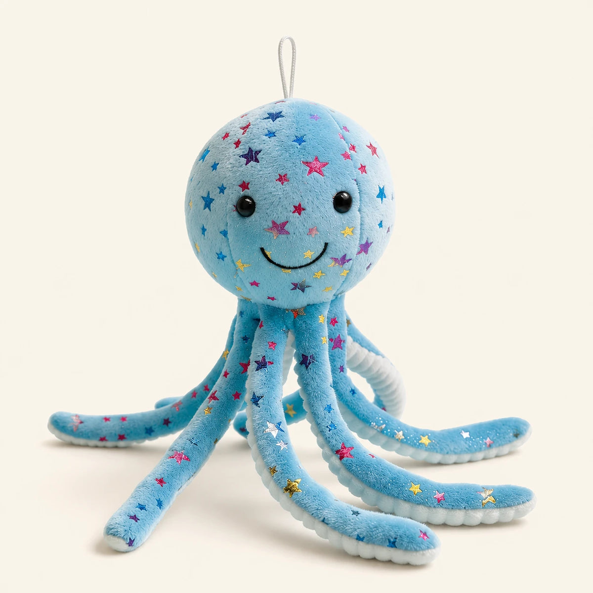 Peluche pieuvre bleue à étoiles, vue de face, fond ivoire