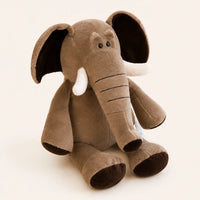 Peluche éléphant grise vue de trois-quarts sur fond ivoire