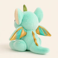Peluche dragon vue de trois-quarts arrière montrant les ailes dorées