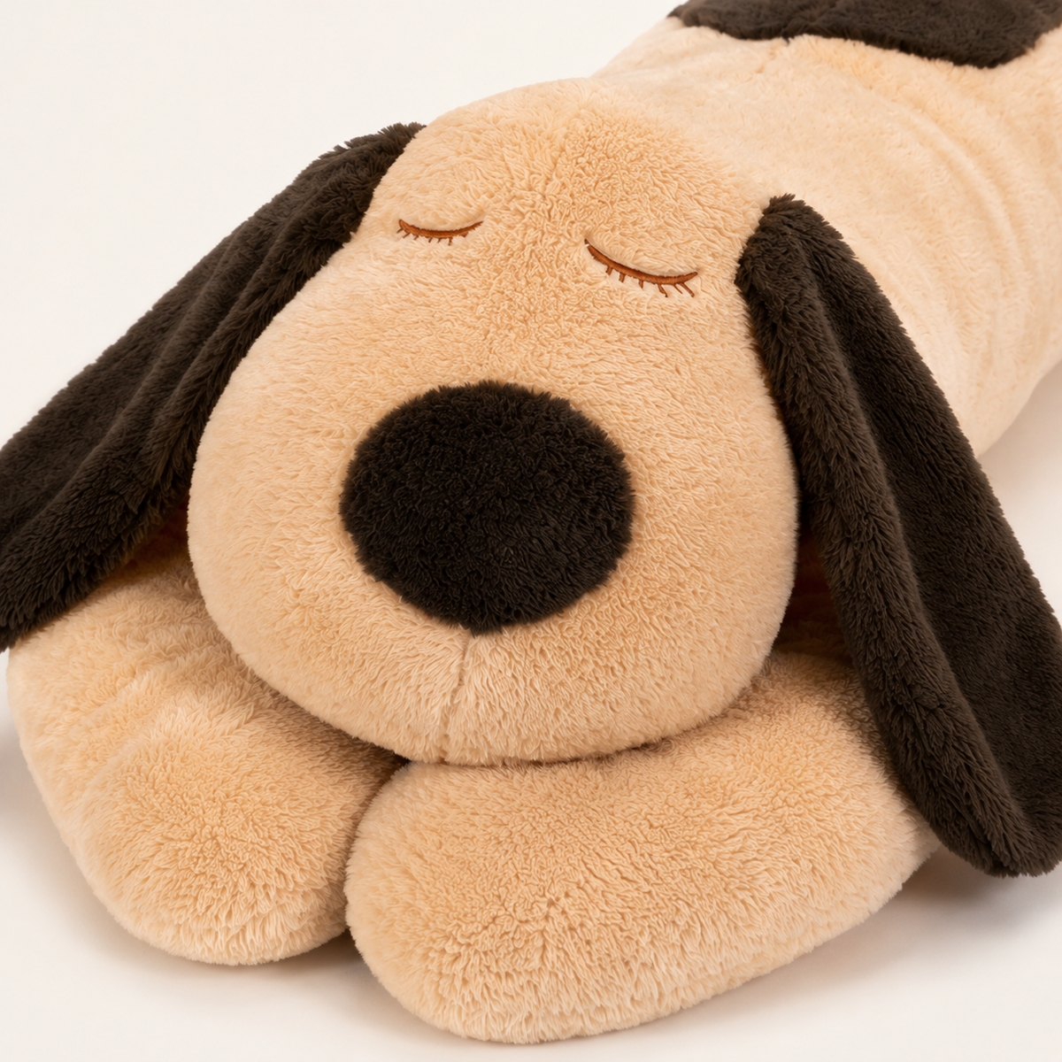 Peluche chien allongé, détail du visage et des oreilles