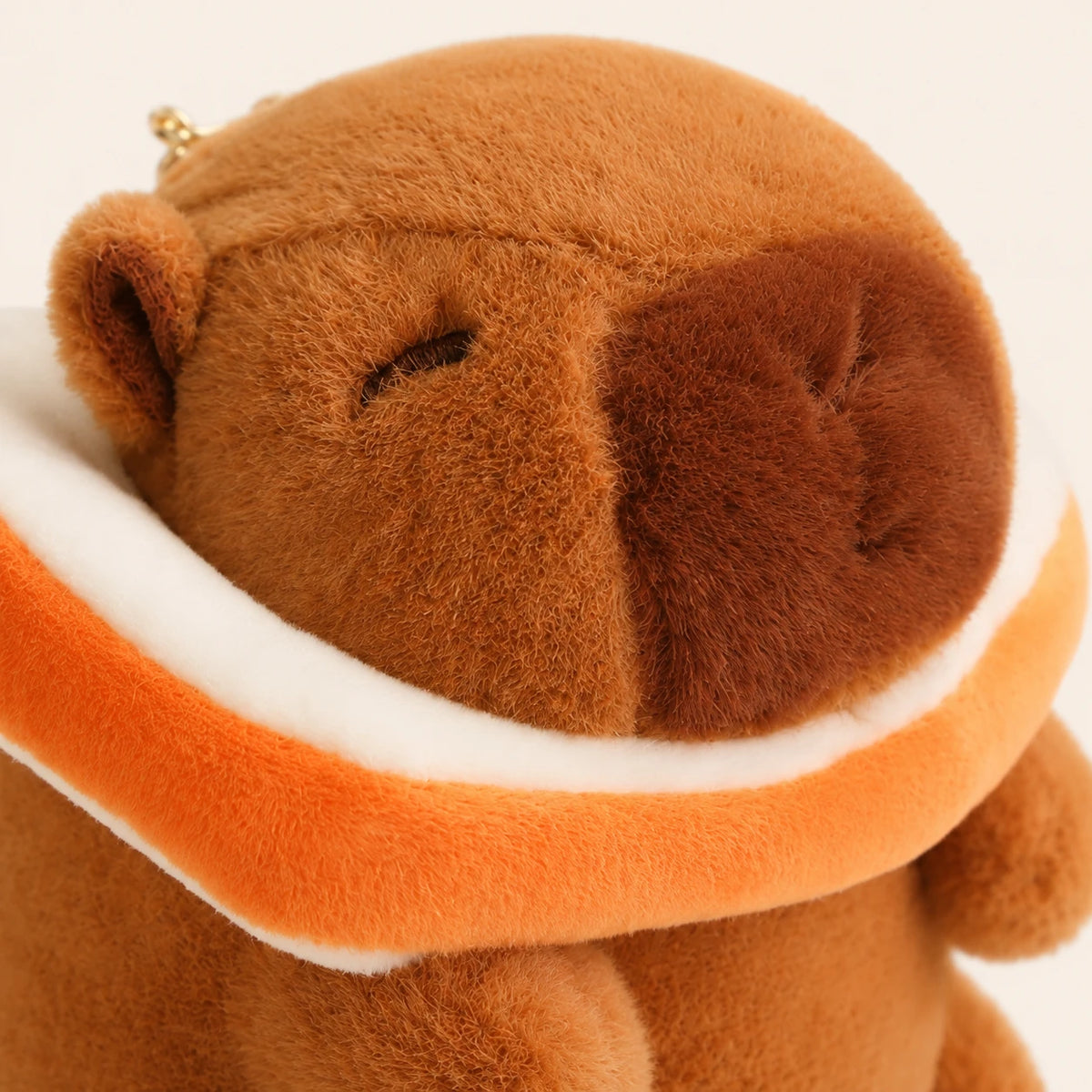 Gros plan du visage de la peluche capybara à bouée - Royaume Peluche