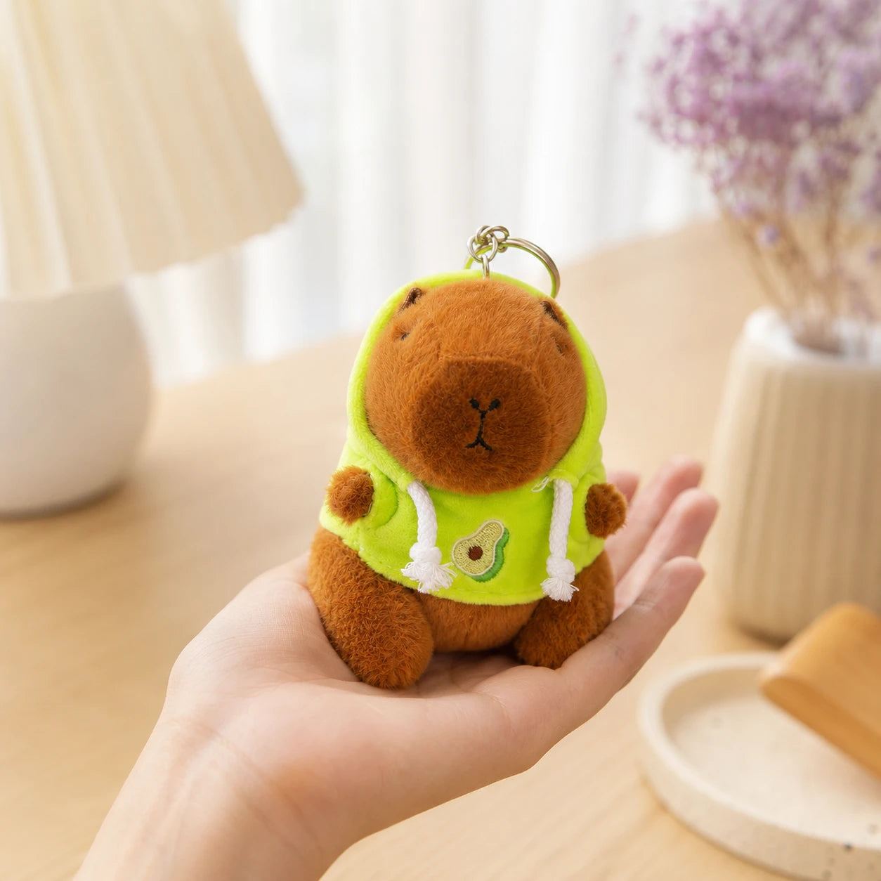 Peluche porte-clés capybara tenue en main, ambiance cosy