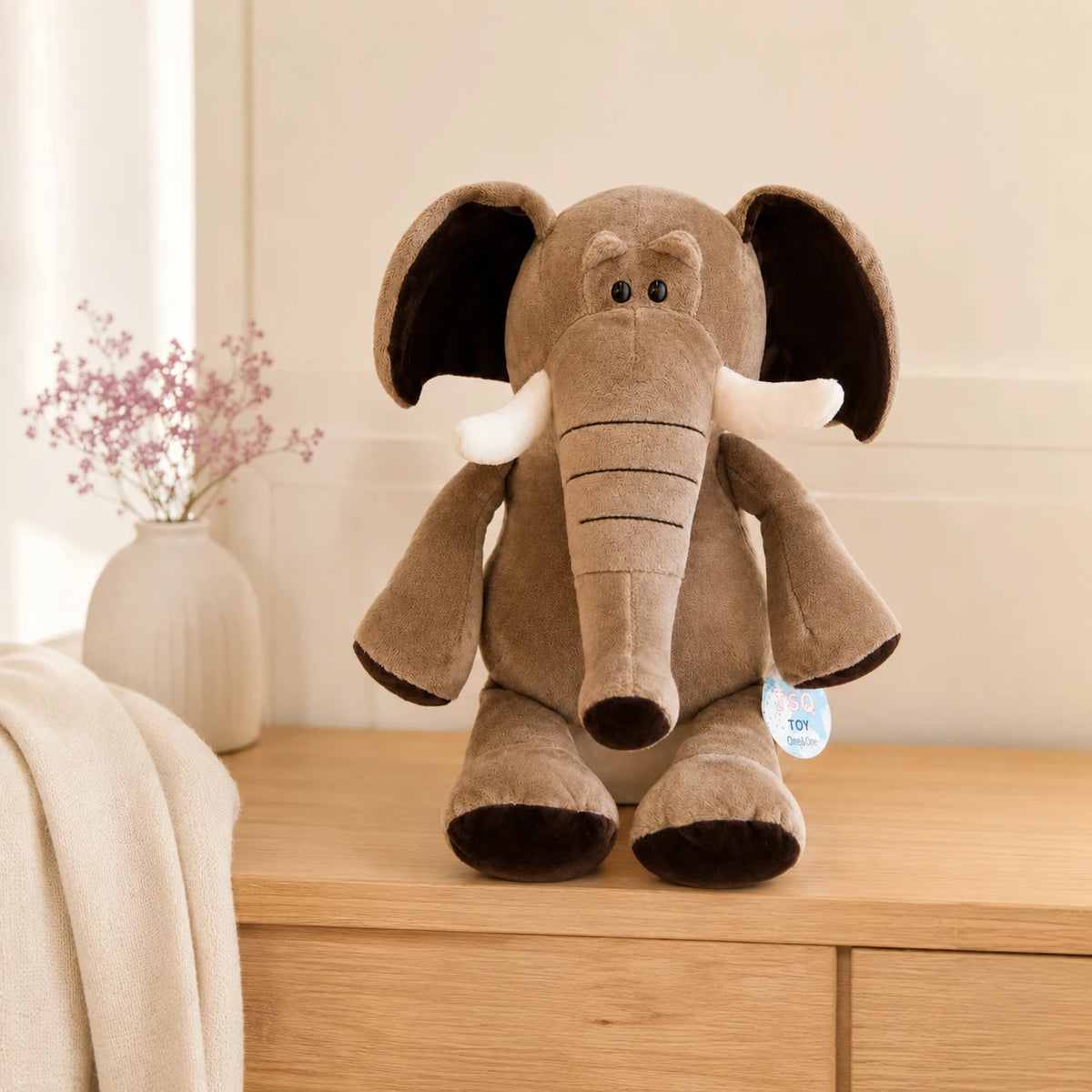 Peluche éléphant grise posée sur une commode, ambiance chaleureuse