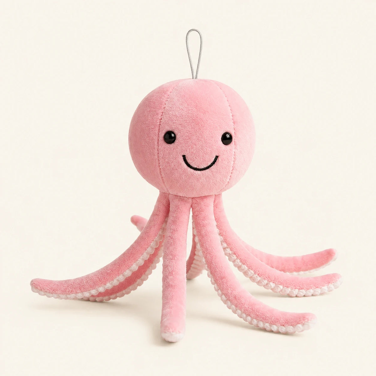 Peluche pieuvre rose, vue de face, fond ivoire