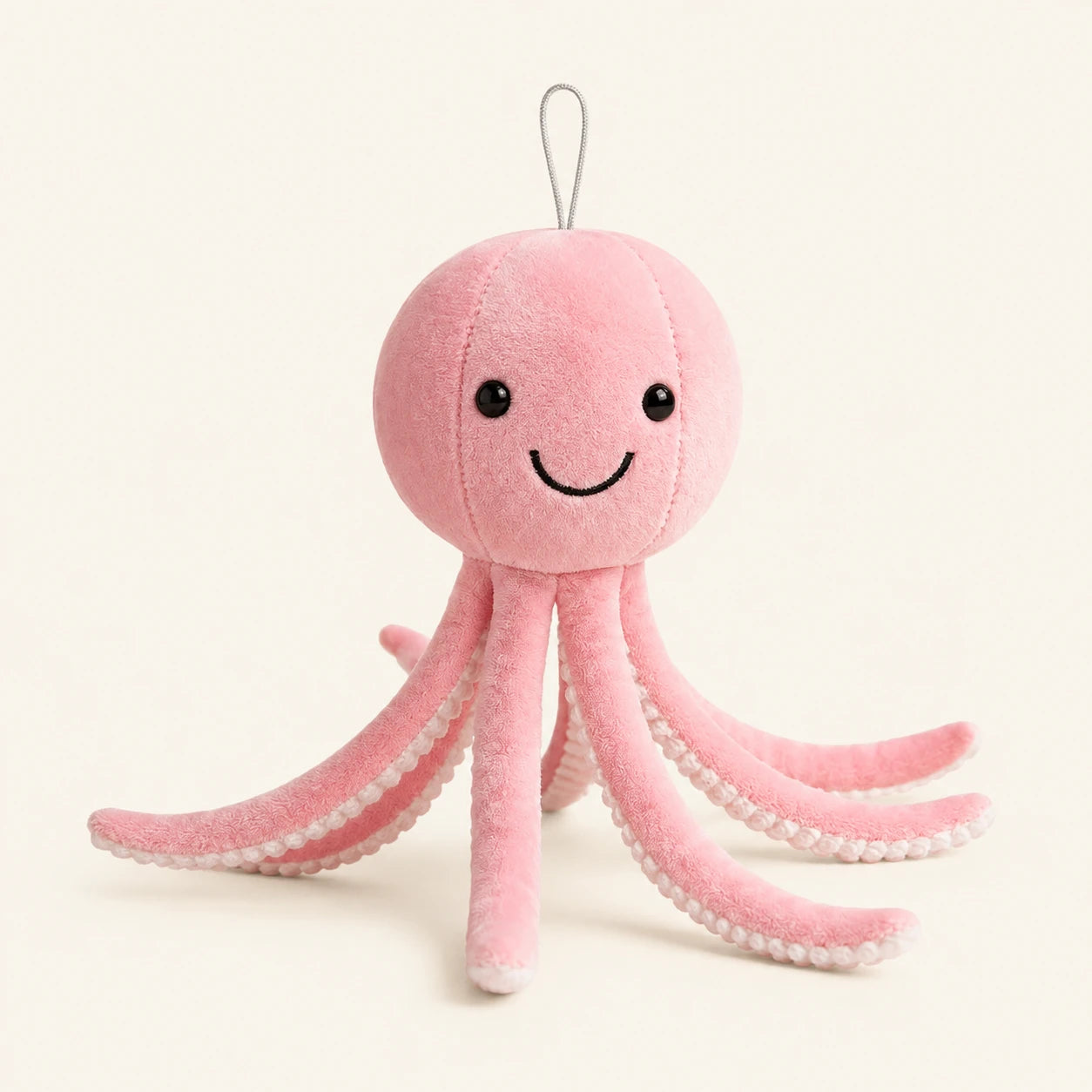 Peluche pieuvre rose, vue de face, fond ivoire