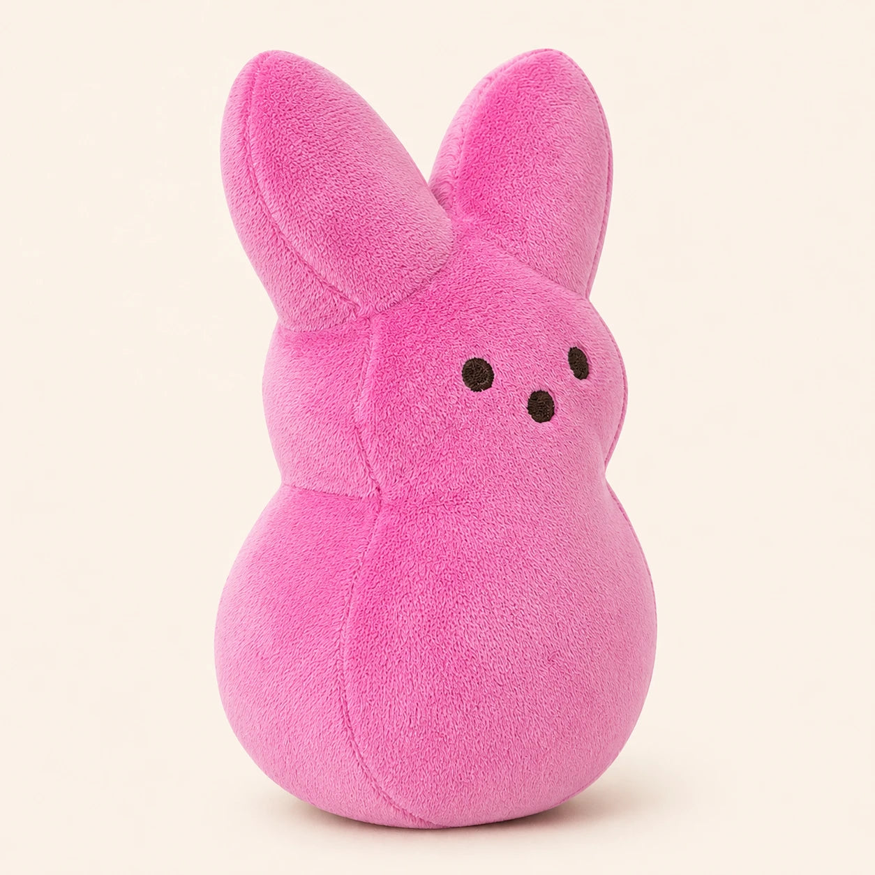 Peluche lapin de Pâques rose, vue de dos, fond ivoire