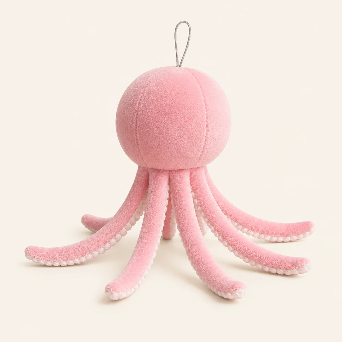Peluche pieuvre rose, vue de trois-quarts, fond ivoire