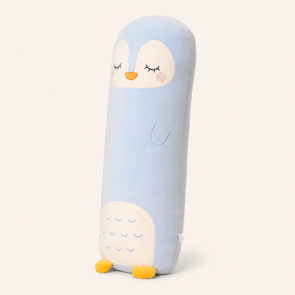 Coussin long peluche pingouin vu de trois-quarts sur fond ivoire