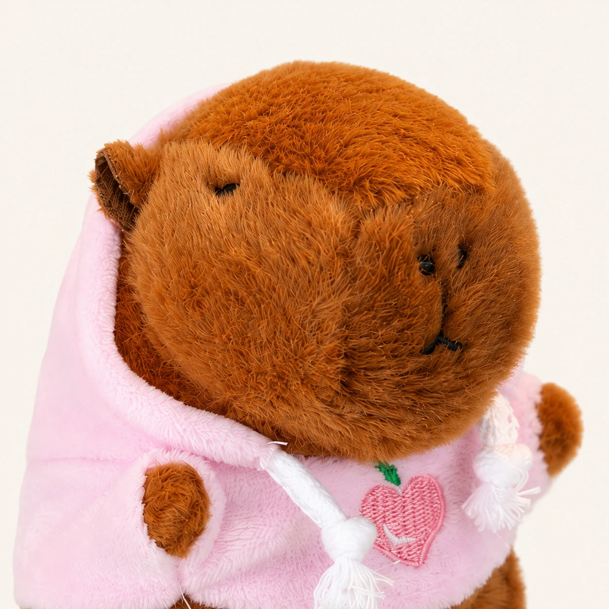 Gros plan visage et broderie cœur de la peluche capybara
