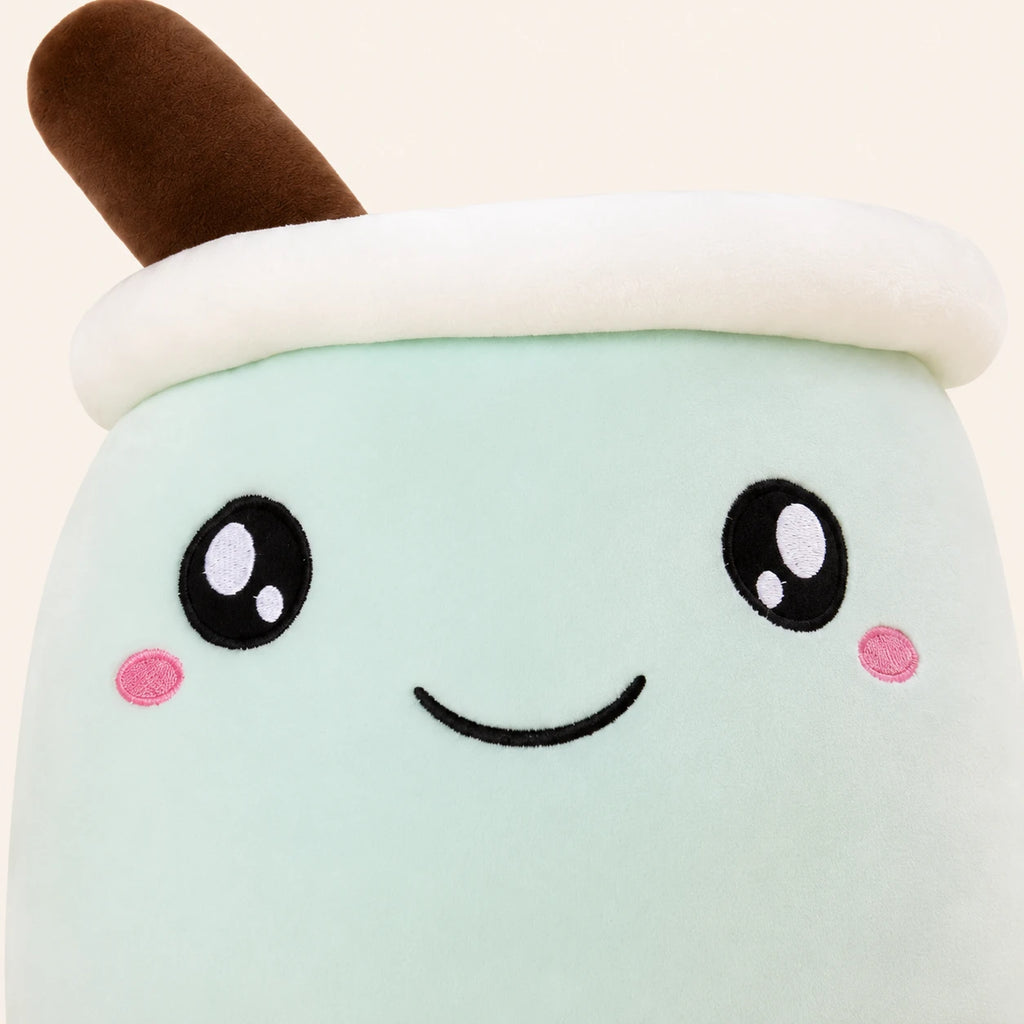 Gros plan sur le visage brodé de la peluche bubble tea vert pomme