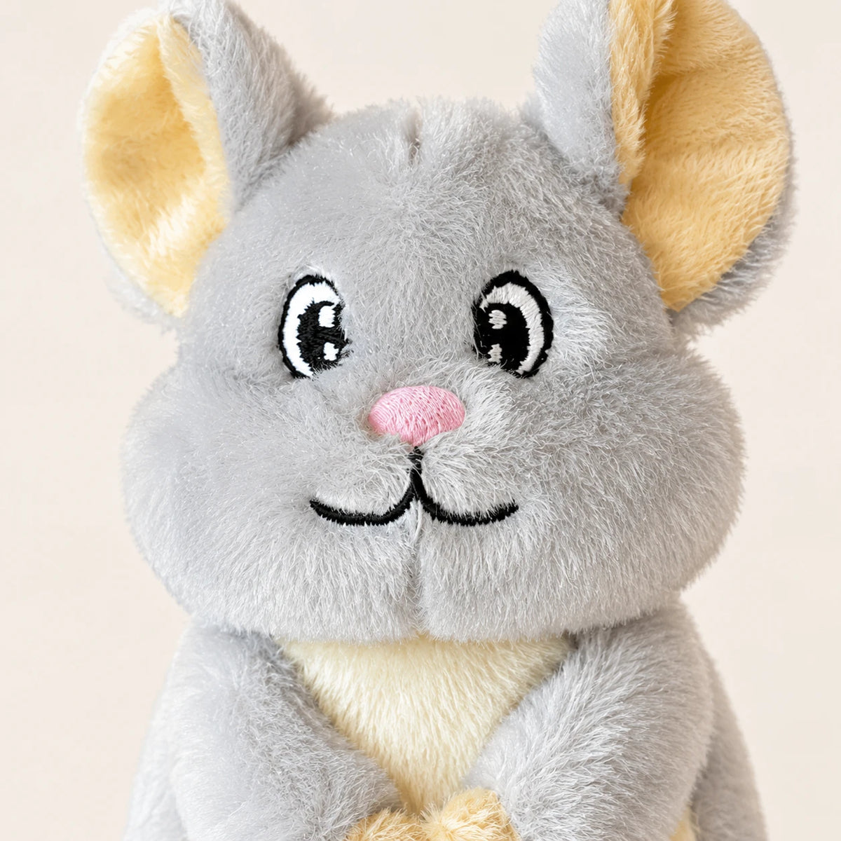 Gros plan du visage de la peluche souris, museau rose et grands yeux