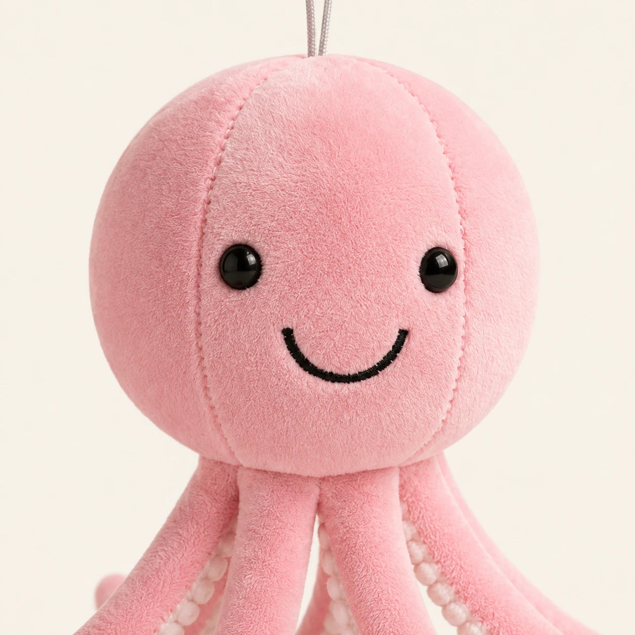 Gros plan sur le visage souriant de la peluche pieuvre rose