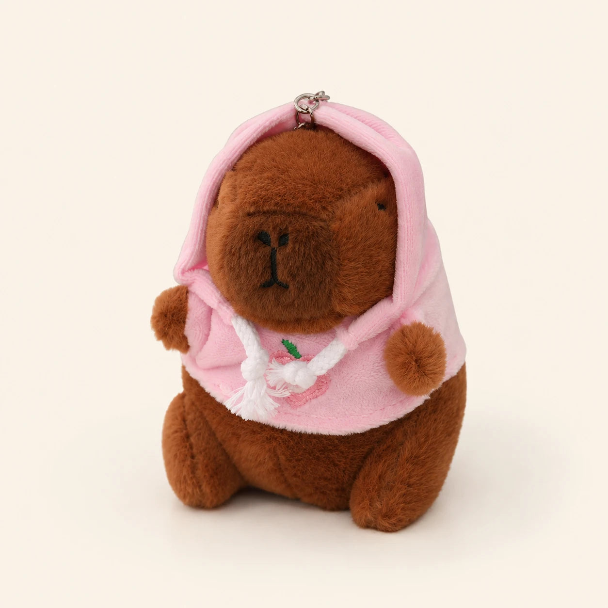 Peluche porte-cles capybara a capuche rose, vue principale sur fond ivoire