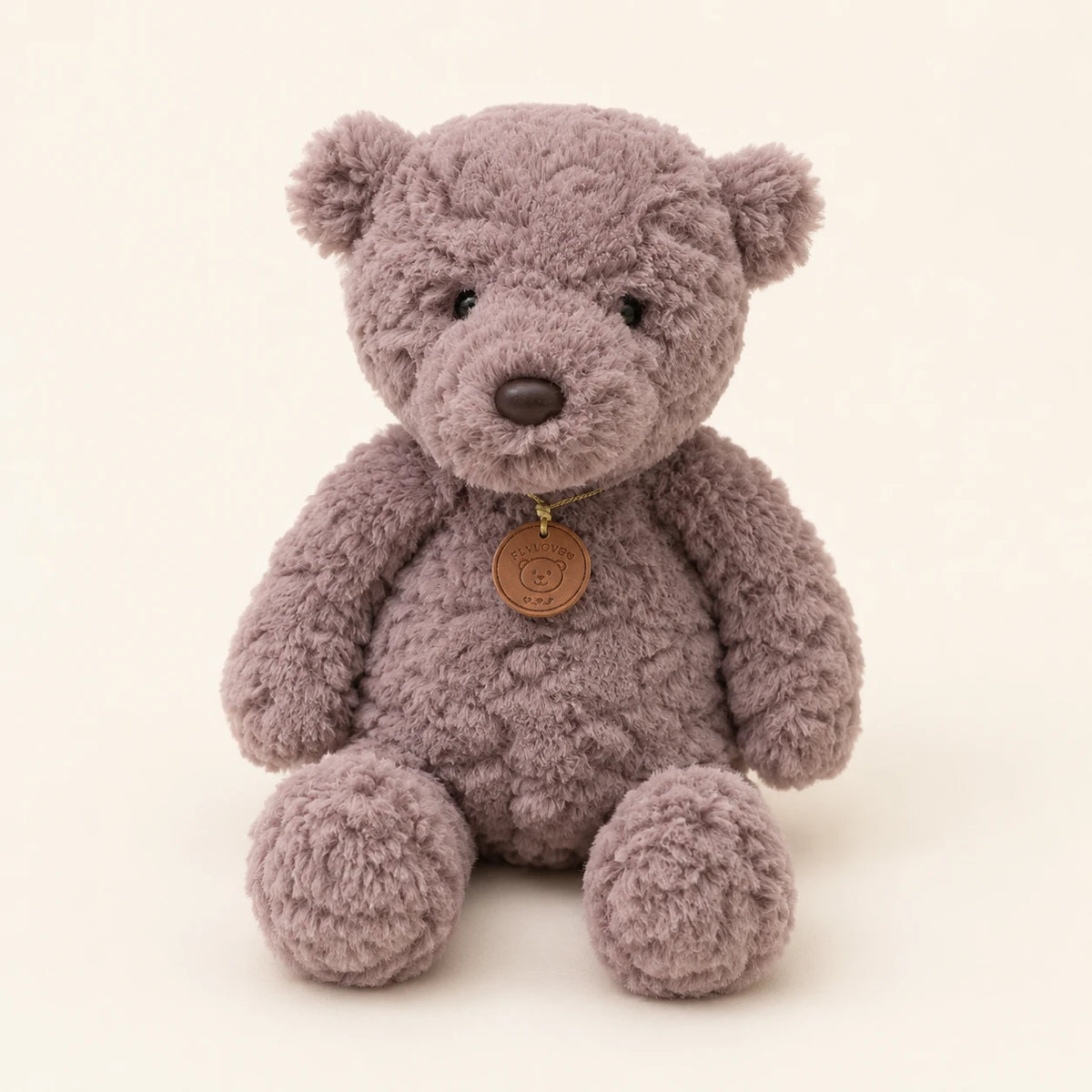 Peluche ours gris assise, vue de face sur fond ivoire
