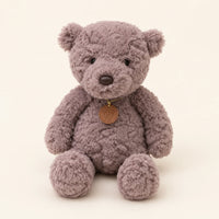 Peluche ours gris assise, vue de face sur fond ivoire