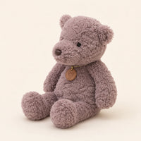 Peluche ours gris vue de trois-quarts sur fond ivoire