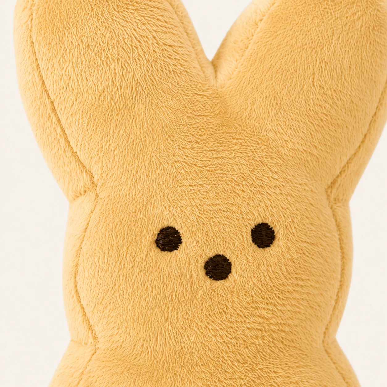 Peluche lapin de Pâques beige, gros plan sur la texture et le visage