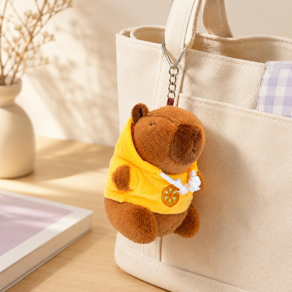 Peluche porte-clés capybara accrochée à un sac tote, ambiance cosy