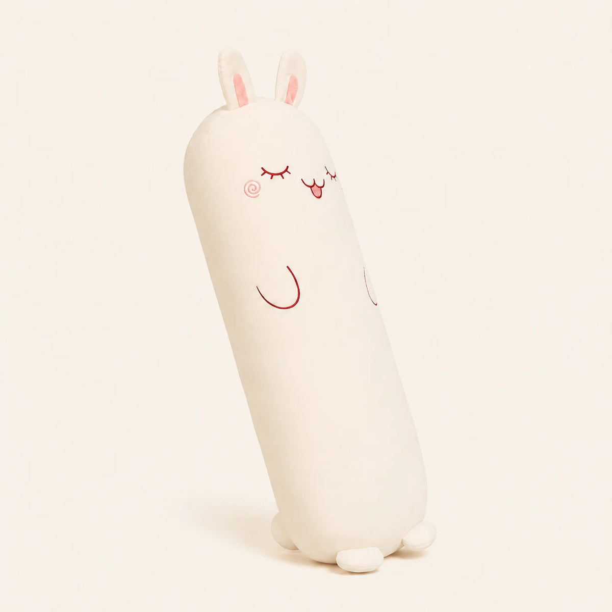 Coussin peluche lapin vu de trois-quarts sur fond ivoire