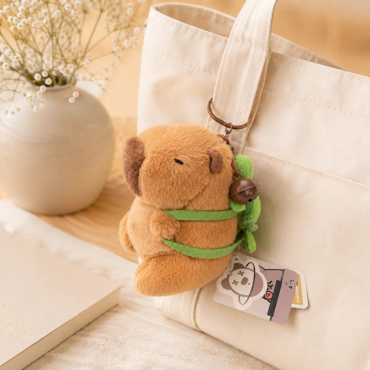 Petite peluche capybara accrochée à un sac, ambiance cosy