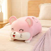 Coussin peluche rose posé sur un lit douillet