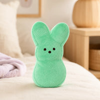 Peluche lapin peeps vert en situation sur un lit