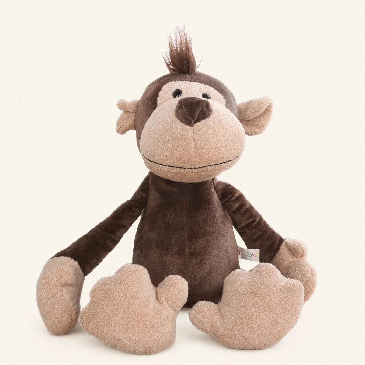 Peluche singe brune assise, vue de face sur fond ivoire