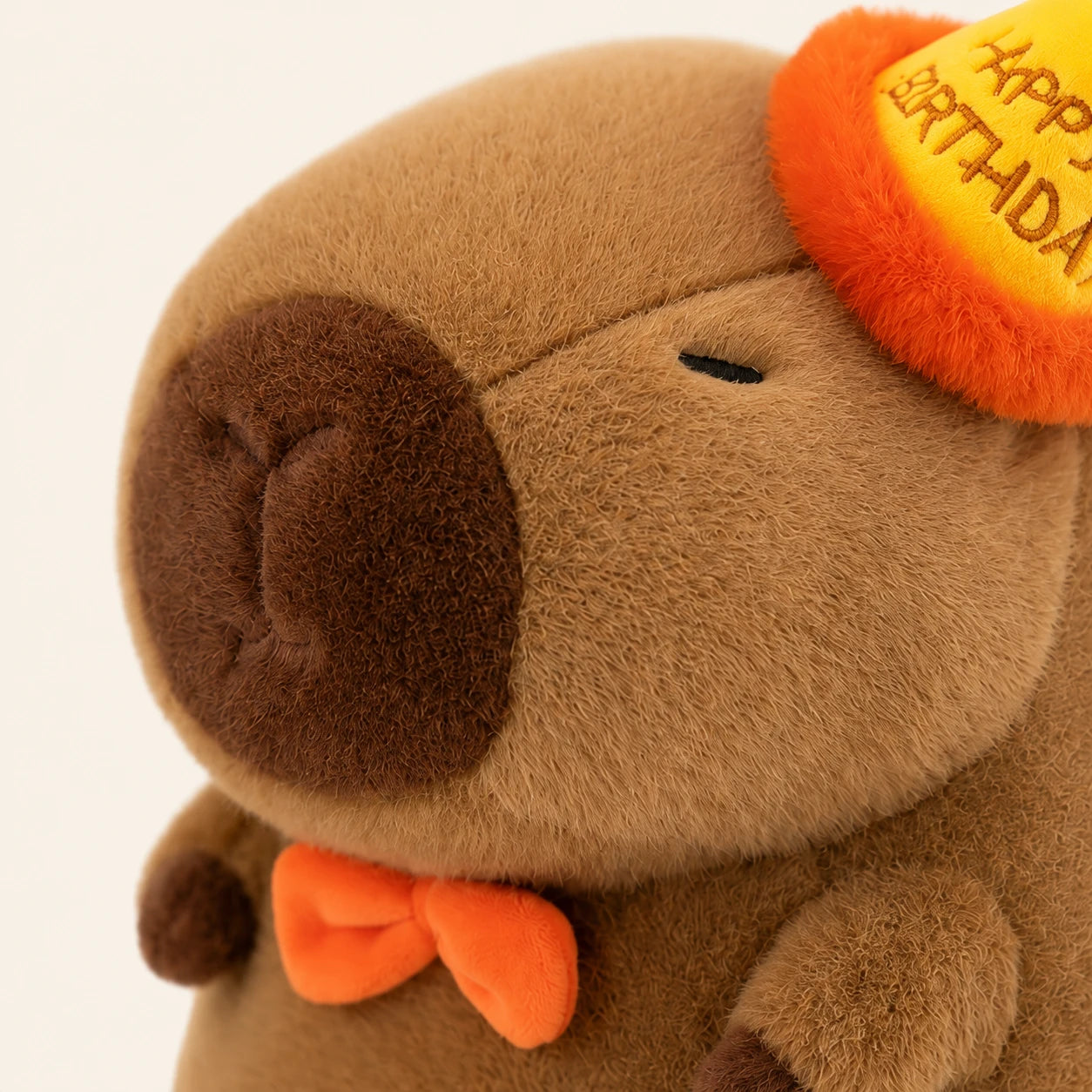Peluche capybara, gros plan sur le visage et le chapeau