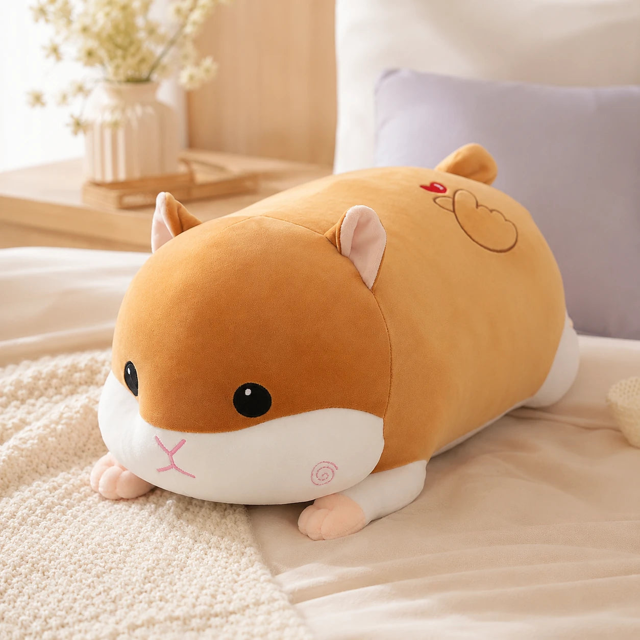 Peluche hamster douillet en situation sur un lit