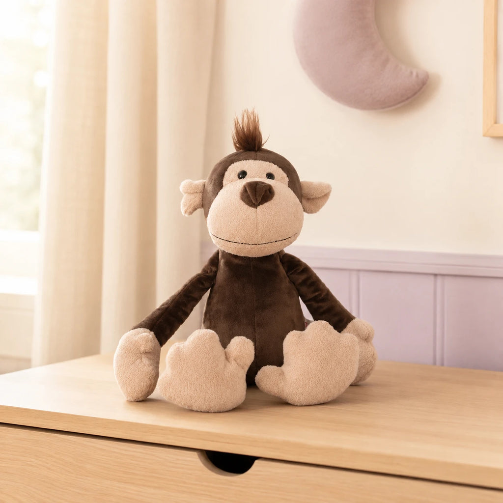 Peluche singe posee sur une commode en bois clair dans une chambre douce