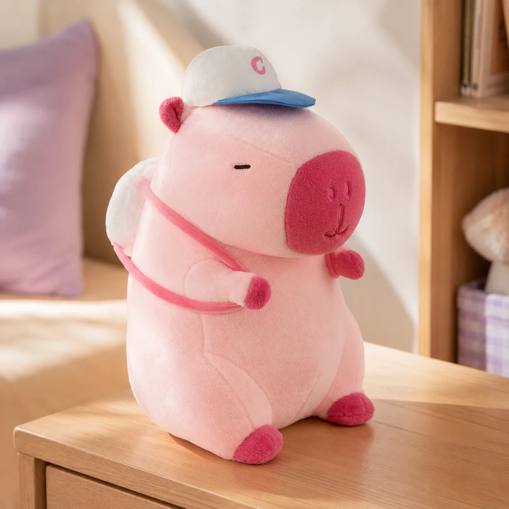 Peluche capybara rose posee sur une table, mise en situation