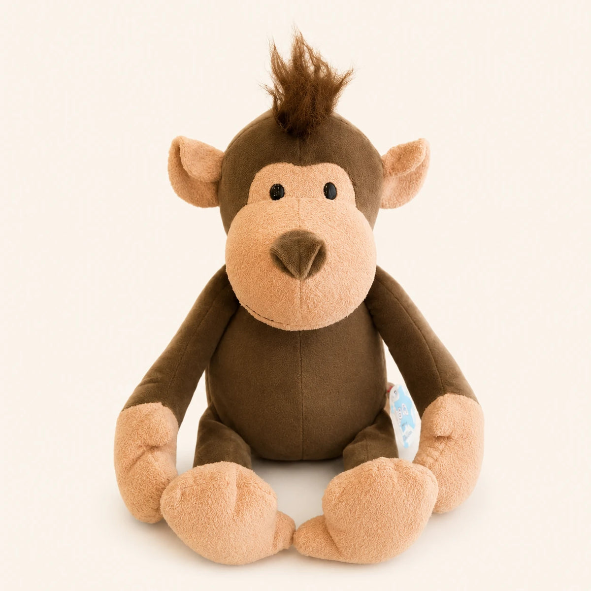Peluche singe brun assise, vue principale, fond ivoire