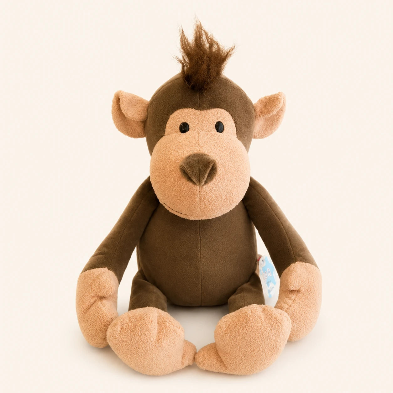 Peluche singe brun assise, vue principale, fond ivoire