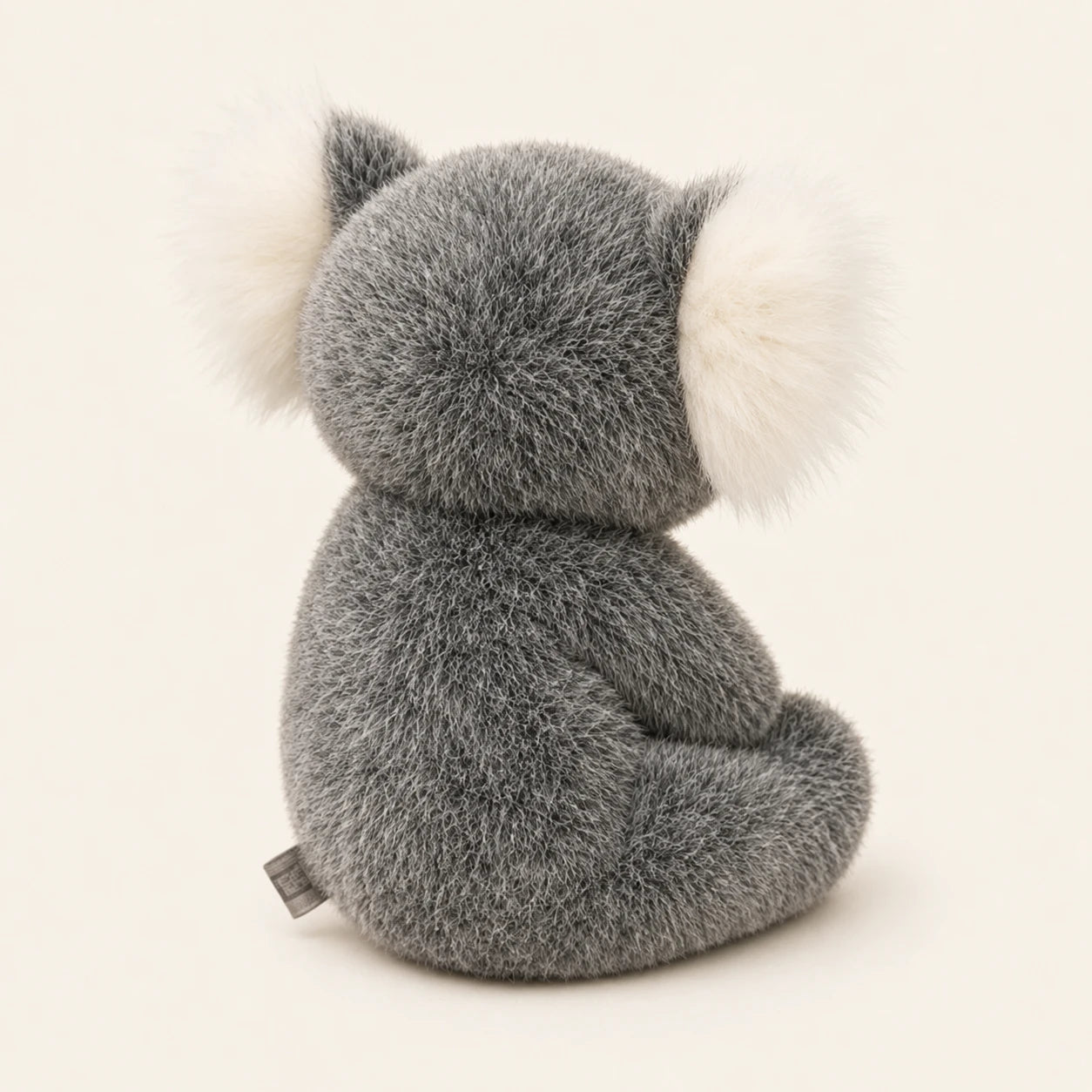 Peluche koala grise vue de dos sur fond ivoire