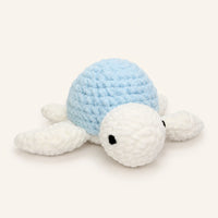 Peluche tortue au crochet, carapace bleue, vue de face, environ 30 cm, fond ivoire
