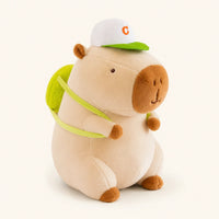 Peluche capybara creme avec casquette et sac a dos vert, vue principale