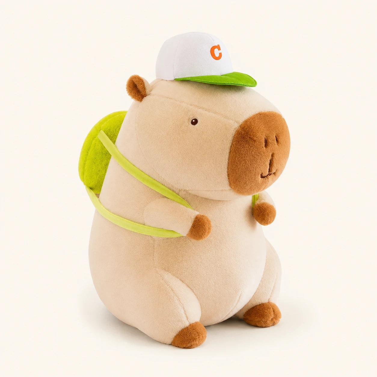Peluche capybara creme avec casquette et sac a dos vert, vue principale
