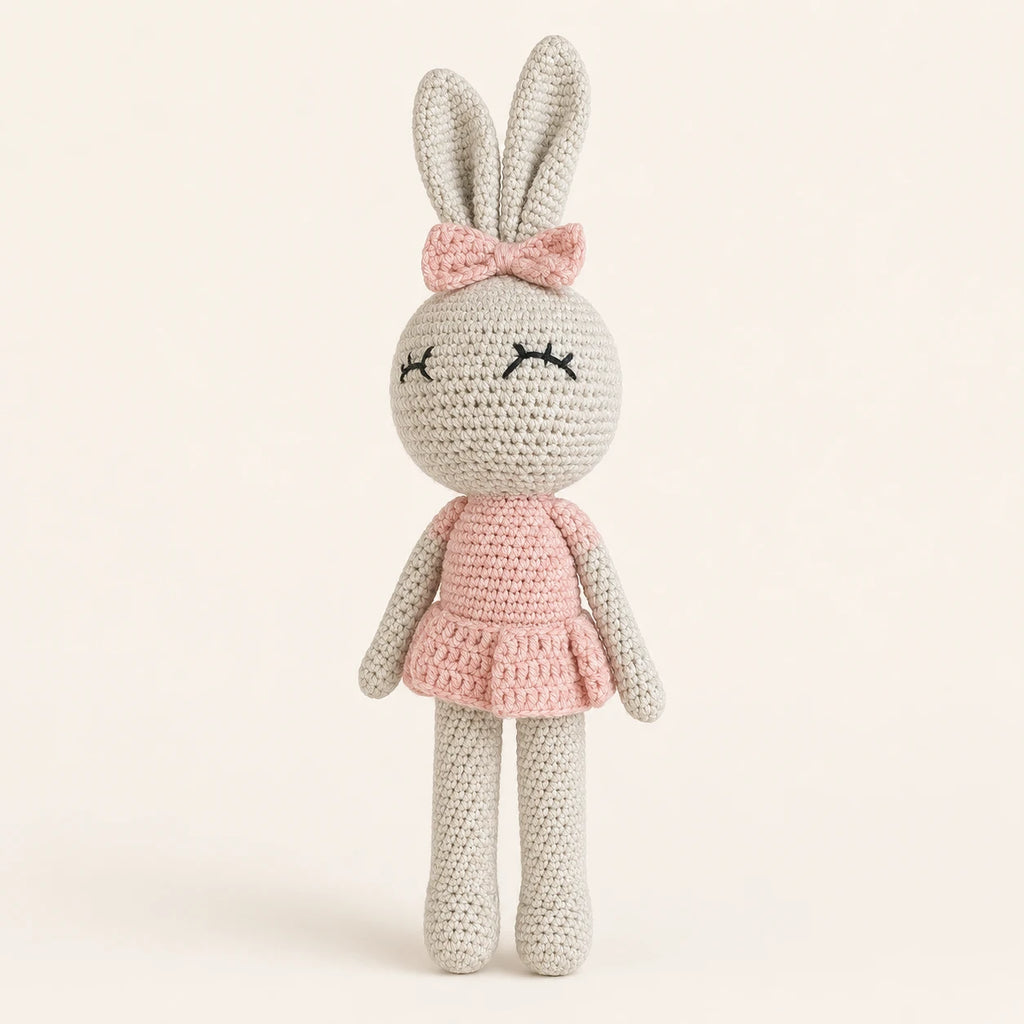 Poupée lapin au crochet en robe rose, vue de face sur fond ivoire