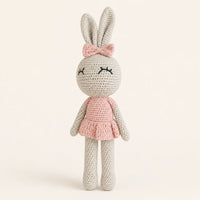 Poupée lapin au crochet en robe rose, vue de face sur fond ivoire