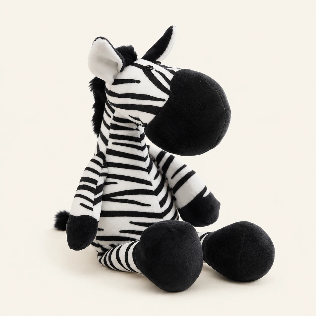 Peluche zèbre réaliste assise, fond beige ivoire